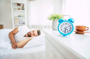 Yakışıklı genç sakallı adamın yakın plan fotoğrafı. Yatakta uzanıyor ve sabah dinleniyor.