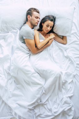 Yatma vakti. Bütün aile uyuyor. Birbirine aşık güzel genç bir çift büyük beyaz yatakta uzanıyor ve dinleniyorlar. Karı koca yatakta birlikteler. Üst görüntü fotoğrafı