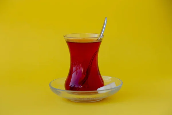 Sarı zemin üzerine şeker küpleriyle Türk çay bardak