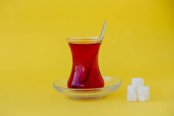 Sarı zemin üzerine şeker küpleriyle Türk çay bardak