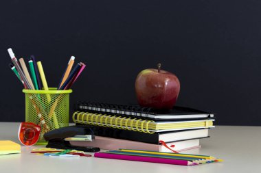 Okula dönüş sağlar. Kitap ve kara tahta arka plan üzerinde kırmızı elma. Kalem ile natürmort. Kopya alanı.