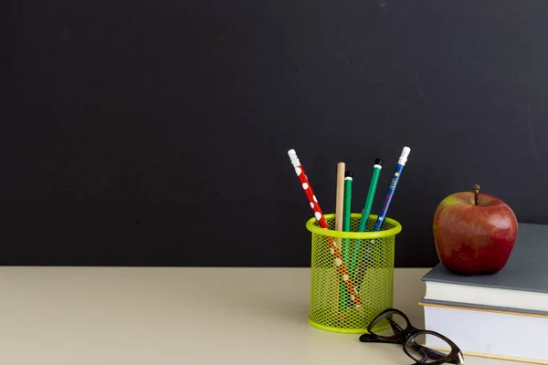 Okula dönüş sağlar. Kitap ve koyu arka plan üzerinde kırmızı elma. Natürmort. Kopya alanı.