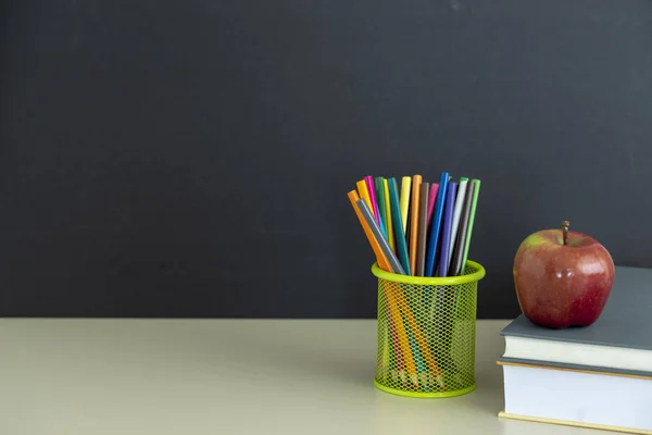 Okula dönüş sağlar. Kitap ve koyu arka plan üzerinde kırmızı elma. Natürmort. Kopya alanı.