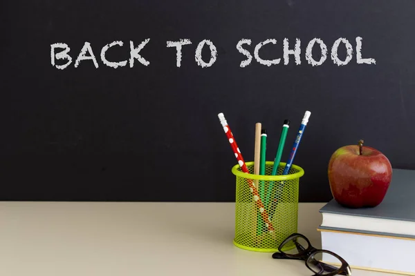 Okula dönüş sağlar. Kitap ve koyu arka plan üzerinde kırmızı elma. Natürmort. Kopya alanı.