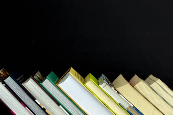 Ahşap masa üzerinde renkli kitap yığını. Metin için yer kopyalayın. Okula dönüş. Eğitim arka plan