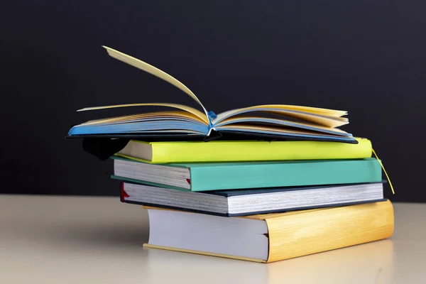 Ahşap masa üzerinde renkli kitap yığını. Metin için yer kopyalayın. Okula dönüş. Eğitim arka plan