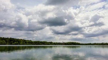 Büyük alçak asılı kötü hava kümülüs bulutlarının zamanı geniş bir nehir boyunca farklı yüksekliklerde ve yönlerde hareket ederek dramatik hava değişikliklerini ve atmosferik derinliği ortaya çıkarıyor.