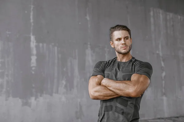 young sporty man posing in studio on grey background