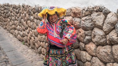 Ollantaytambo, Peru - Ağustos 2017: Onun bebek koyun Ollantaytambo, Peru'daki yerli giyim ile belirsiz bir Perulu kadın portresi