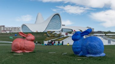 Bakü, Azerbaycan - Nisan 2018: Haydar Aliyev Merkezi önünde renkli tavşan heykeller, Irak-İngilizler tarafından tasarlanmış bina kompleksi mimar Zaha Hadid.