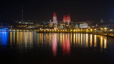 Bakü, Azerbaycan-Mayıs 2018: Bakü 'de alev kuleleri ve Hazar Denizi Körfezinde yansımalar ile gece şehir manzarası