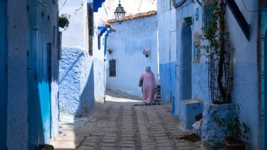 : Chefchaouen, Morocco - Nisan 2018: Chefchaouen Şehir Fas, Kuzey Afrika mavi Medine'de yürüyen kimliği belirsiz kadın