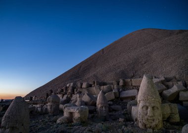 Kommagene heykeller Nemrut Dağı zirvesinde yıldız gökyüzünde, Adıyaman, Türkiye ile günbatımı sırasında. 2150 metre yüksekliğinde Nemrut Dağı üstündeki taş kafa. Türkiye