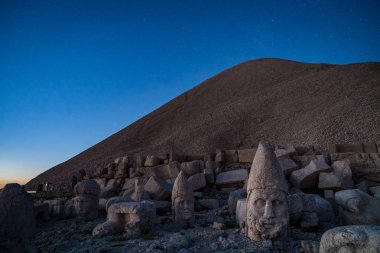 Kommagene heykeller Nemrut Dağı zirvesinde yıldız gökyüzünde, Adıyaman, Türkiye ile günbatımı sırasında. 2150 metre yüksekliğinde Nemrut Dağı üstündeki taş kafa. Türkiye