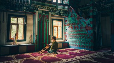 Artvin, Türkiye - Temmuz 2018: Artvin, Türkiye'de iremit maral Köyü Camii renkli dekorasyon içinde dua kimliği belirsiz erkek