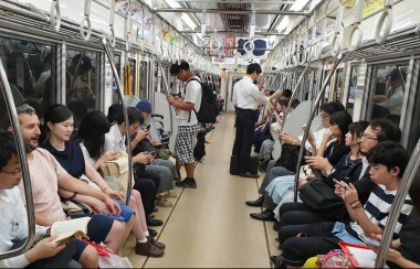 Tokyo, Japonya - Ağustos 2018: metro vagonu binme süre içinde akıllı telefonlar kullanan kişiler. Modern toplumda iletişim eksikliği kavramı.