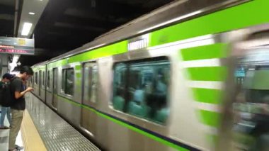 Tokyo, Japonya - Ağustos 2018: commuters sırada beklerken bir metro istasyonu platformu gelen tren