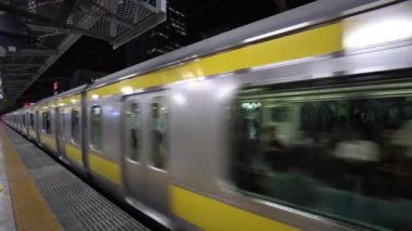 Tokyo, Japonya - Ağustos 2018: commuters sırada beklerken bir metro istasyonu platformu gelen tren