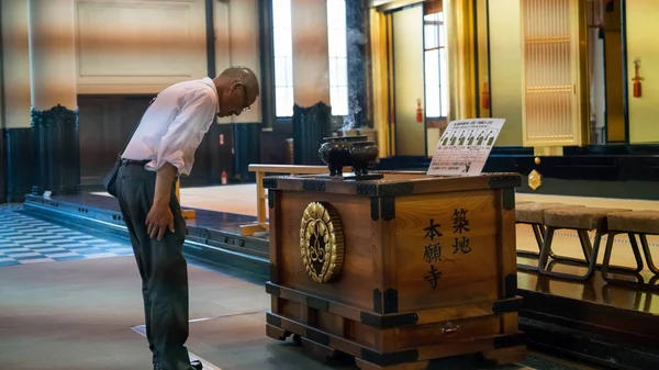 Tokyo, Japonya - Ağustos 2018: Tsukiji Honganji Jodo Shinshu Budist tapınak içinde dua kimliği belirsiz adam