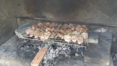 Piknik sırasında taş şömine odun ateşi üzerinde tavuk ızgara barbekü yapma