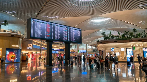 Tabel waktu informasi penerbangan di Bandara Istanbul yang baru dengan orang-orang yang berjalan kaki, Istanbul, Turki Stok Foto Bebas Royalti