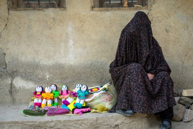 Iranian woman selling hand made dolls for tourists in village of Masuleh, Gilan, Iran clipart