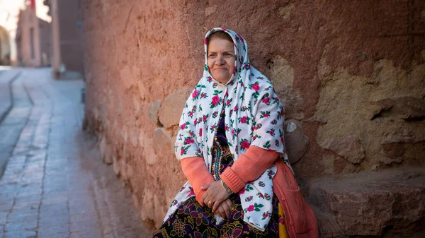 Mujer con ropa persa tradicional está sentada en una vieja calle en Abyahen, Irán —  Fotos de Stock