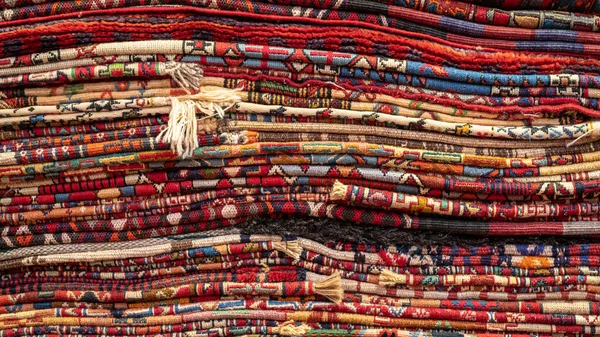 Montón de alfombras y alfombras tradicionales iraníes en una tienda de alfombras, Isfihan, Irán — Foto de Stock