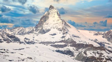 Karlı Matterhorn tepesinin ikonik görüntüsü dramatik gökyüzü ve gün batımında bulutlar, Zermatt, İsviçre