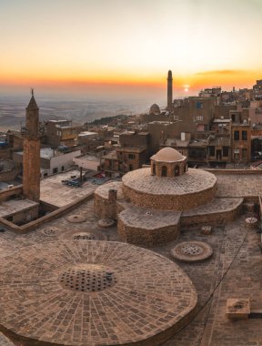 Mardin, Türkiye - Ocak 2020: Günbatımında çatısı Türk hamamı ve minareleri olan eski Mardin kenti