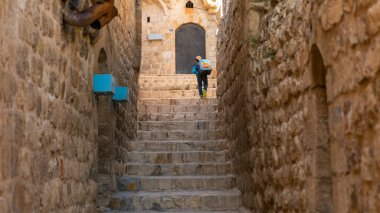Mardin, Türkiye - Ocak 2020: Mardin 'in dar taştan yolunda yürüyen kimliği belirsiz çocuk