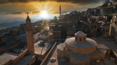 Mardin, Türkiye - Ocak 2020: Günbatımında Türk hamam ve minarelerinin çatısı olan eski Mardin kenti