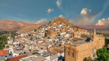 Savur, Mardin, Türkiye - Ocak 2020: Gökyüzü dramatik bir tepenin üzerinde eski taş evleri olan Savur Kasabası