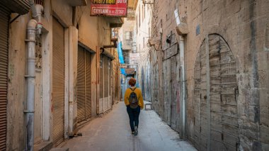 Mardin, Türkiye - Ocak 2020: Mardin 'in dar bir taş yolunda yürüyen kimliği belirsiz kadın