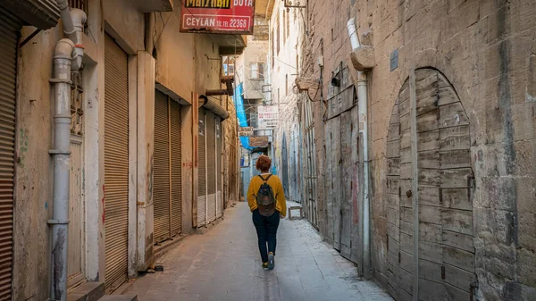 Mardin, Türkiye - Ocak 2020: Mardin 'in dar bir taş yolunda yürüyen kimliği belirsiz kadın