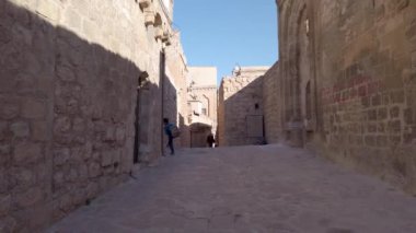 Mardin, Türkiye - Kasım 2019: Mardin 'in dar taştan caddeleri ve yerel halk yürüyor