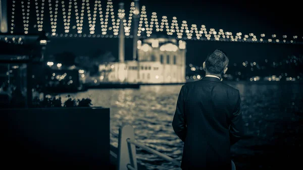 İstanbul, Türkiye - Haziran 2014: Ortakoy camii ve 15 Temmuz Şehitler Köprüsü 'nü izleyen kimliği belirsiz adam