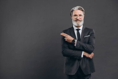 İş ve modaya uygun sakallı, gri takım elbiseli olgun bir adam elini fotokopi alanının üzerine koyar.