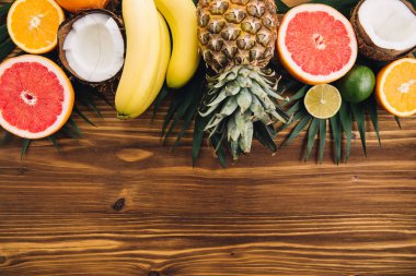 Yaz meyveleri. Tropik palmiye yaprakları, ananas, hindistan cevizi, greyfurt, portakal ve muz. Düz konum, üst görünüm, kopyalama alanı
