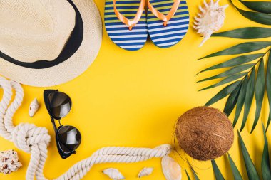 Yaz kavramı. Seyahat aksesuarları: hasır şapka, hindistan cevizi, halat kabuğu, terlik ve güneş gözlüğü..