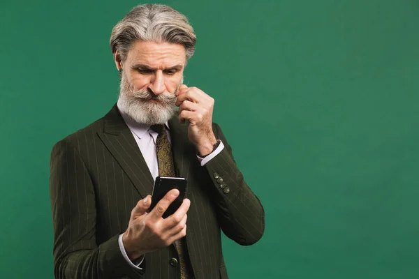 Κομψός Μεσήλικας Χακί Κοστούμι Κοιτάζει Τηλέφωνο Και Φτιάχνει Μουστάκι Και — Φωτογραφία Αρχείου