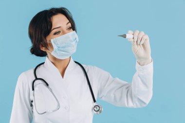 Steteskoplu kadın doktor elektrikli termometre tutuyor. covid-19 kavramı