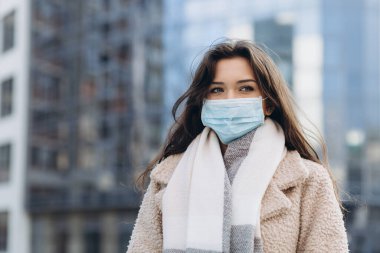 Dışarıda tıbbi koruma maskesi takan bir kadın. Şehirde grip virüsü salgını, koronavirüs COVID-19 salgını ve bulaşıcı hastalıkların önlenmesi