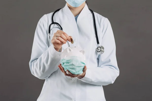 Lekarz Stetoskopem Trzymający Skarbonkę Masce Medycznej Koncepcja Koronawiru — Zdjęcie stockowe