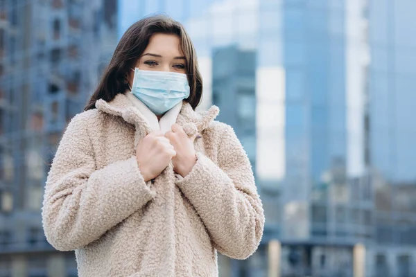 Female wearing medical protective mask outdoors. Health protection prevention during flu virus outbreak, coronavirus COVID-19 epidemic and infectious diseases in the city