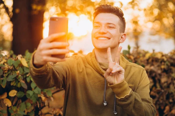 Portrét Pohledného Šťastného Chlapa Úsměvem Kyticí Podzimních Listů Selfie Parku — Stock fotografie