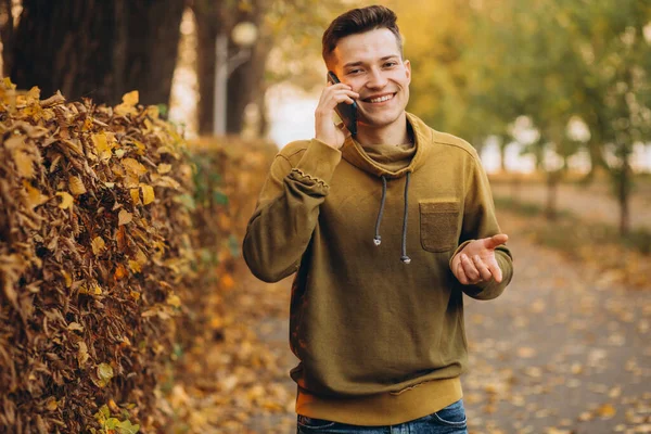 Portrét Pohledného Šťastného Chlapa Jak Usmívá Mluví Telefonu Podzimním Parku — Stock fotografie