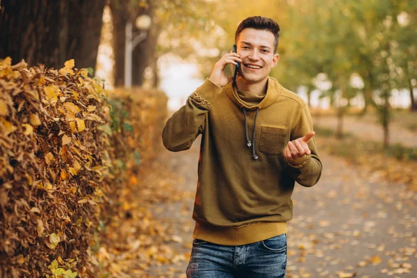 Portrét Pohledného Šťastného Chlapa Jak Usmívá Mluví Telefonu Podzimním Parku — Stock fotografie