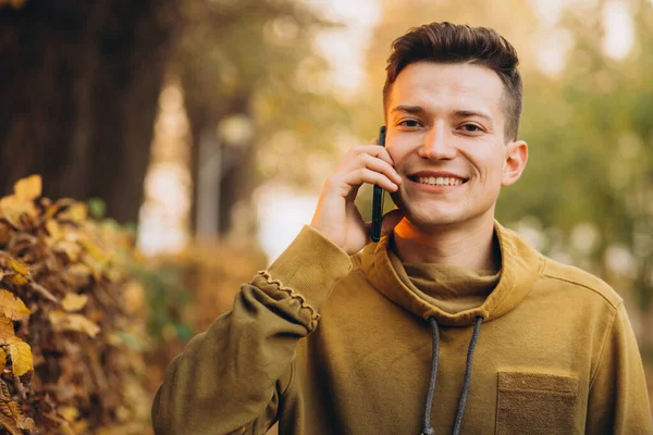 Portrét Pohledného Šťastného Chlapa Jak Usmívá Mluví Telefonu Podzimním Parku — Stock fotografie