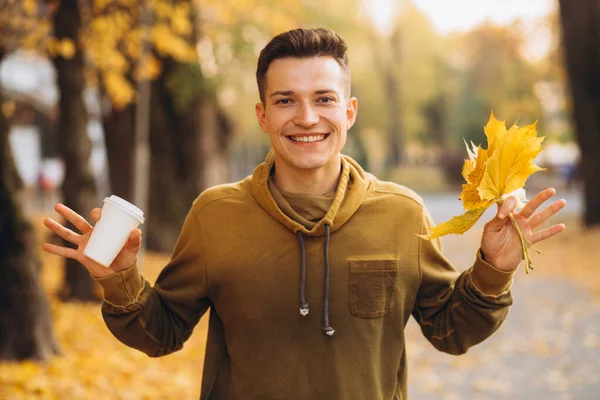 Hezký Šťastný Chlap Kyticí Žlutých Listů Úsměvem Pití Kávy Podzimním — Stock fotografie